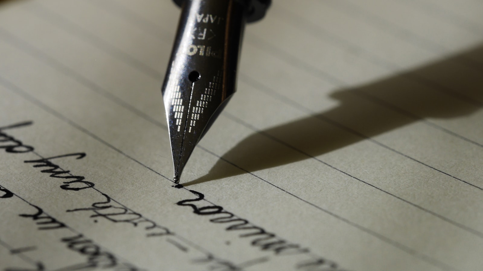 An open notebook and pen on a calm desk beside a window